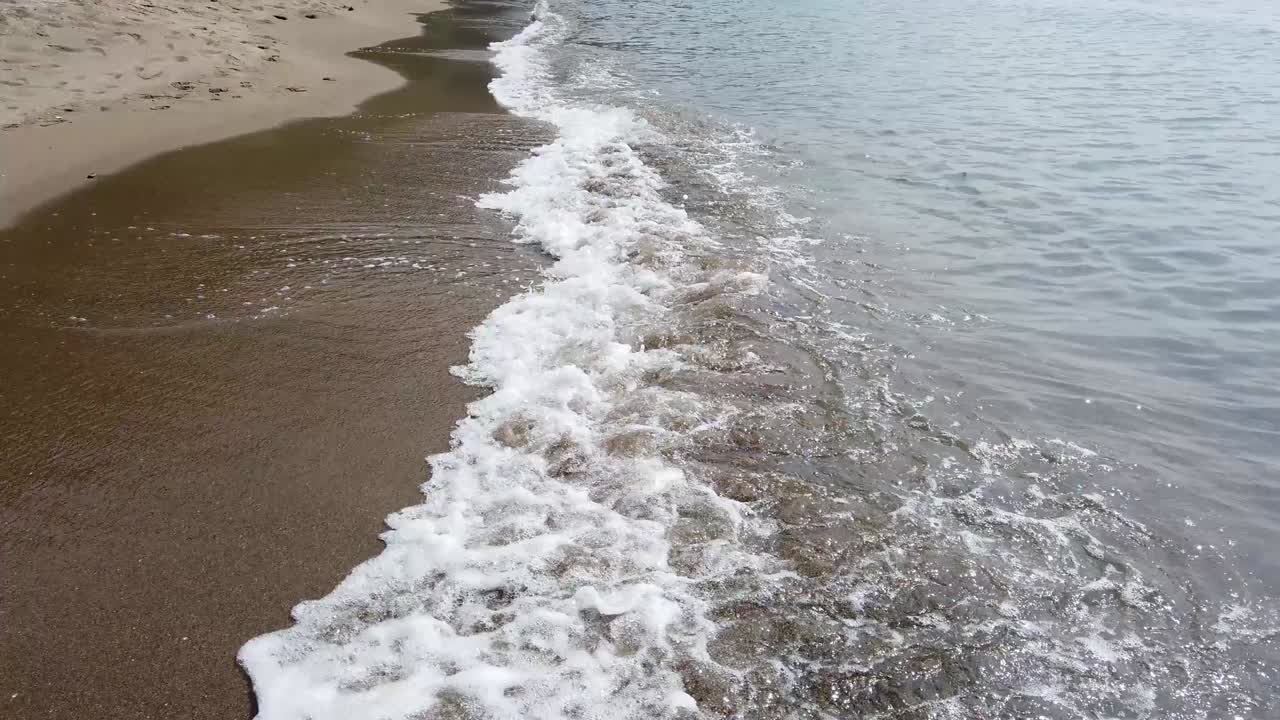 las olas llegan suavemente a la playa, luego se retiran como la puesta de sol. una hermosa puesta de sol sobre un mar en turquía