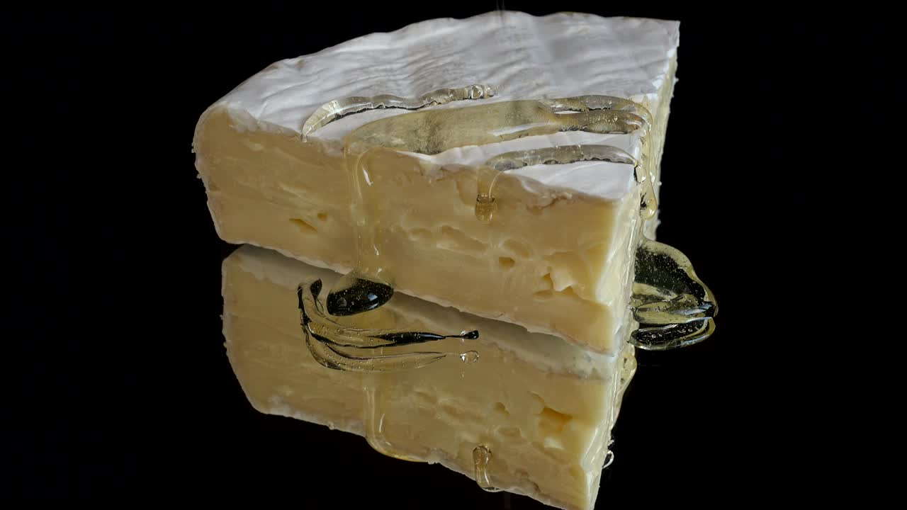 거울 같은 검은 바탕에 브리 치즈에서 흘러내리는 방울.