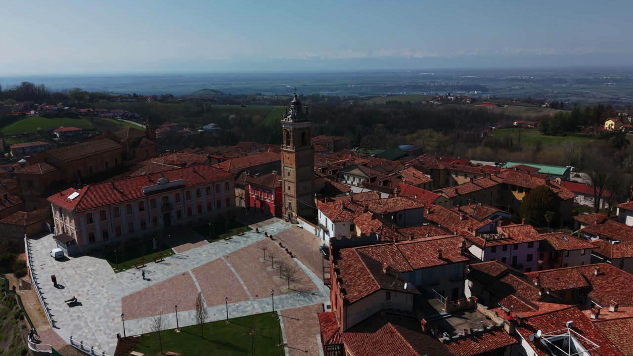 Iconic Piazza Castello viewpoint in La Morra with the famous bell tower, Piedmont, drone aerial orbit