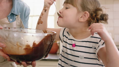 niña feliz ayudando a su madre a hornear en la cocina vertiendo masa en la bandeja de hornear preparando receta de pastel casero en casa