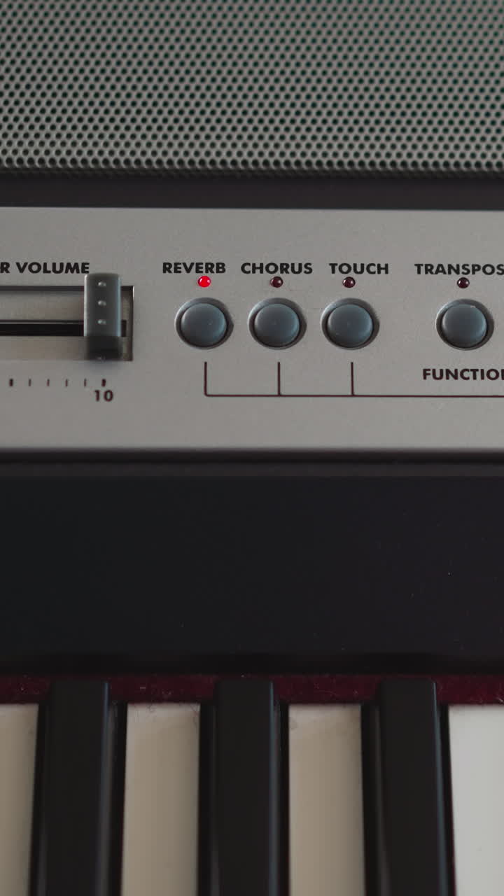 Young pianist increases volume of sound of synthesizer on control panel. Musician sets parameters of playing electronic musical instrument closeup