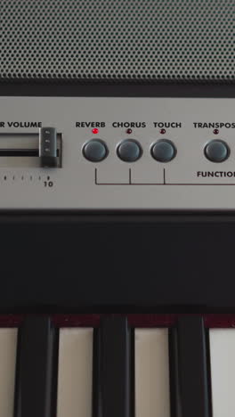 young pianist increases volume of sound of synthesizer on control panel. musician sets parameters of playing electronic musical instrument closeup