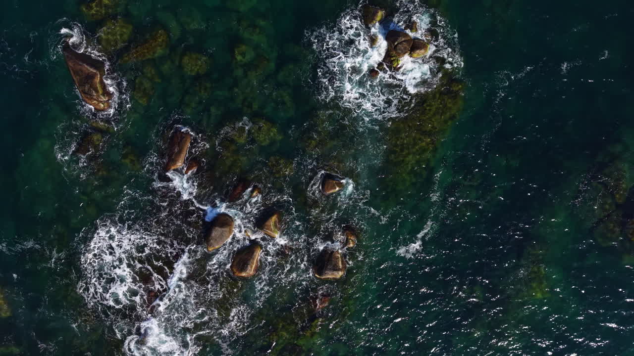 Waves crashing over rocky shoreline at dawn, capturing the beauty of nature's rugged coast