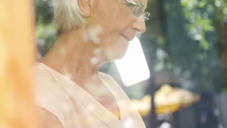 senior woman using mobile phone in cafe 4k