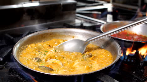 chef preparing seafood risotto in restaurant, close-up, mediterranean