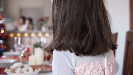 girl in white setting the christmas table