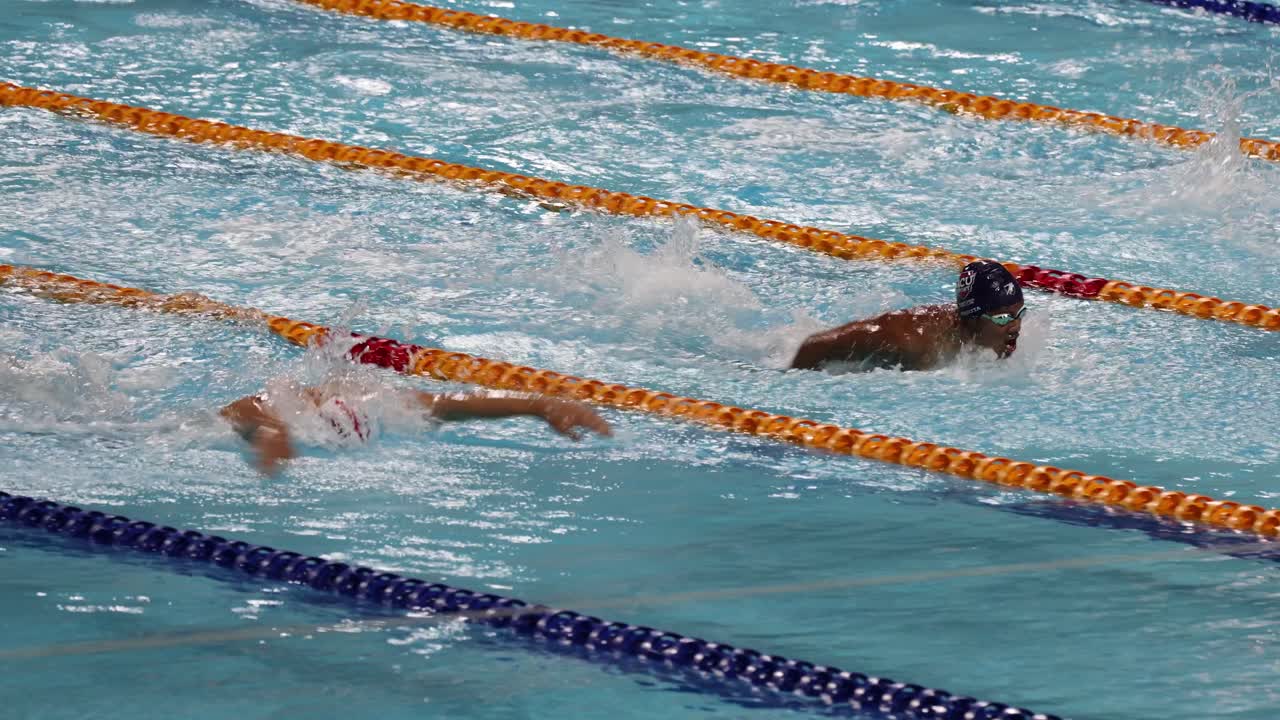 수영 선수 들 이 수영장 에 있는 차선 에서 경주 하고 있다