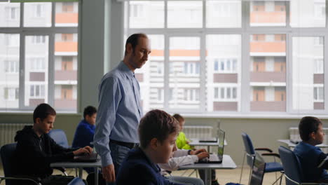 teacher interacting with students in a computer lab