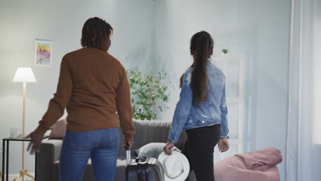 amigas con maletas dejan la habitación mirando a su alrededor