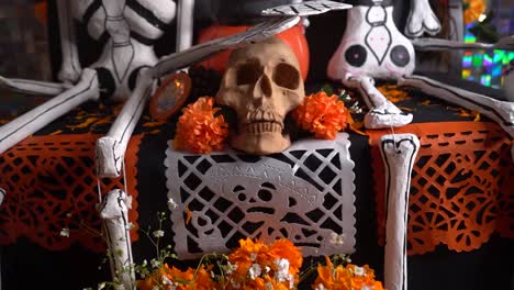 skull and paper mache skeleton decorations on day of the dead altar