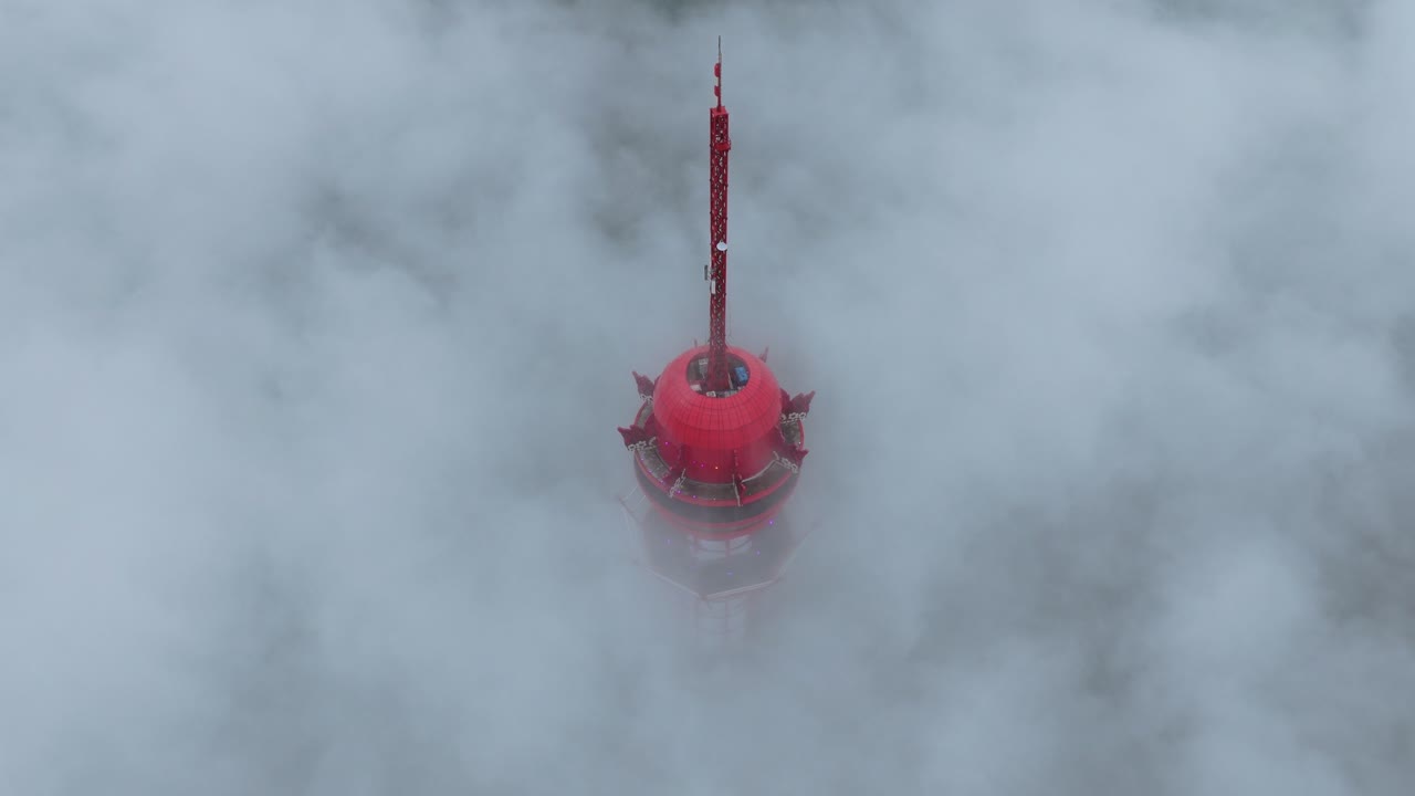 Torre di osservazione rossa che si erge sopra un mare di nuvole