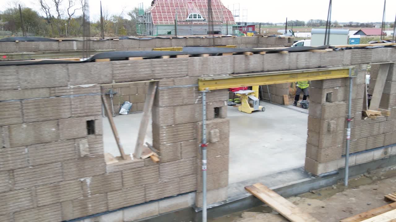 panorámica paralela cerca de una pared de cáñamo de bloques prefabricados en un sitio de construcción