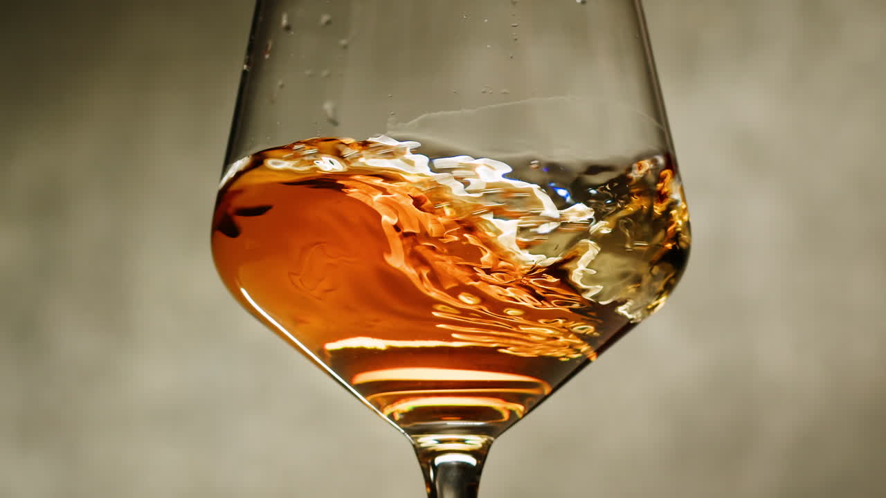 Rose Orange or white wine bottle and glass against a sunset in a peaceful vineyard, pouring of ecological natural wine. Cheers, hands with wine glasses, drinking alcohol.