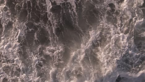 Aerial-slow-motion-birds-eye-view-above-foaming-ocean-waves