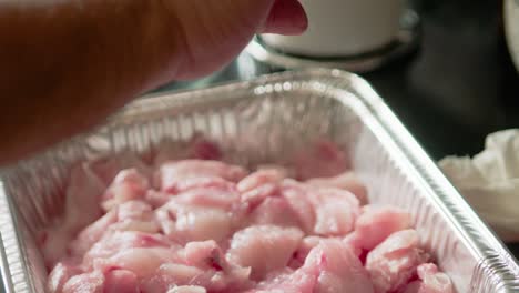 espolvorear sal sobre el pescado en un recipiente de estaño a cámara lenta