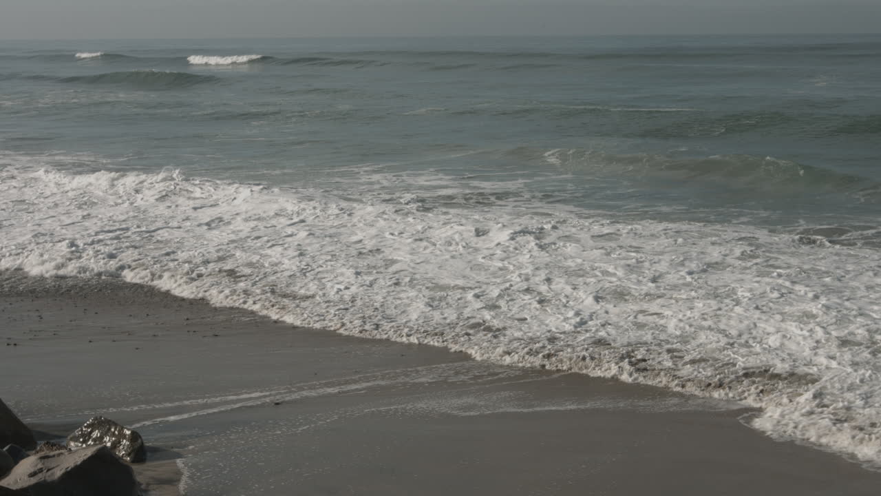 Onde dell'oceano sulla riva di una spiaggia all'interno della Riserva Naturale Statale Torrey Pines a San Diego, CA.