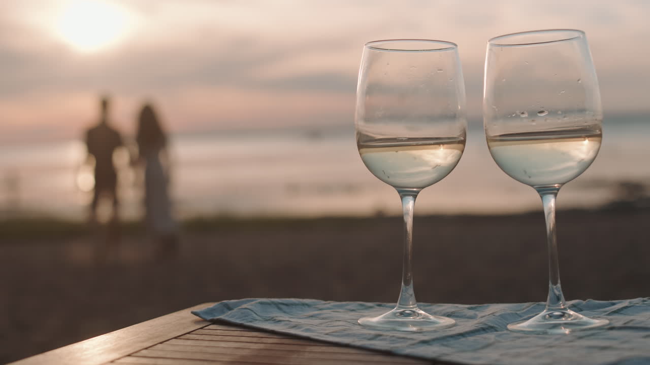 Wine Glasses on Seashore on Sunset