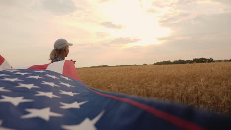 Ein-Patriotischer-Bauer-Mit-Einer-US-Flagge-Steht-In-Der-Nähe-Eines-Reifen-Weizenfeldes-Und-Hält-Eine-Fahne-Für-Einen-Der-Rande