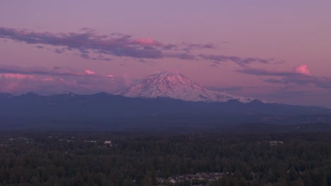 aerial view of forests surrounding mount rainier in washington state during sunset.
