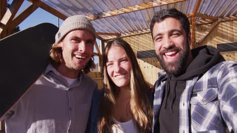 video de skateboardistas mujeres y hombres felices y diversos mirando a la cámara en el parque de skate