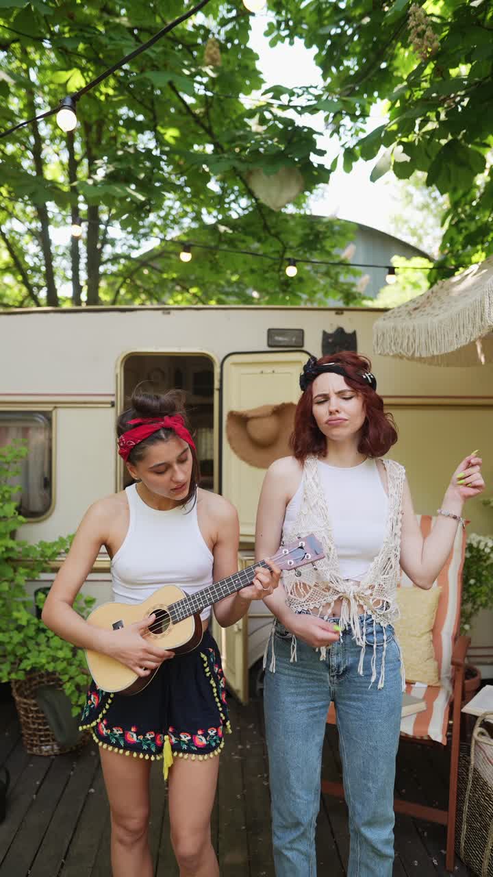 dos amigos tocando el ukulele en un jardín de verano