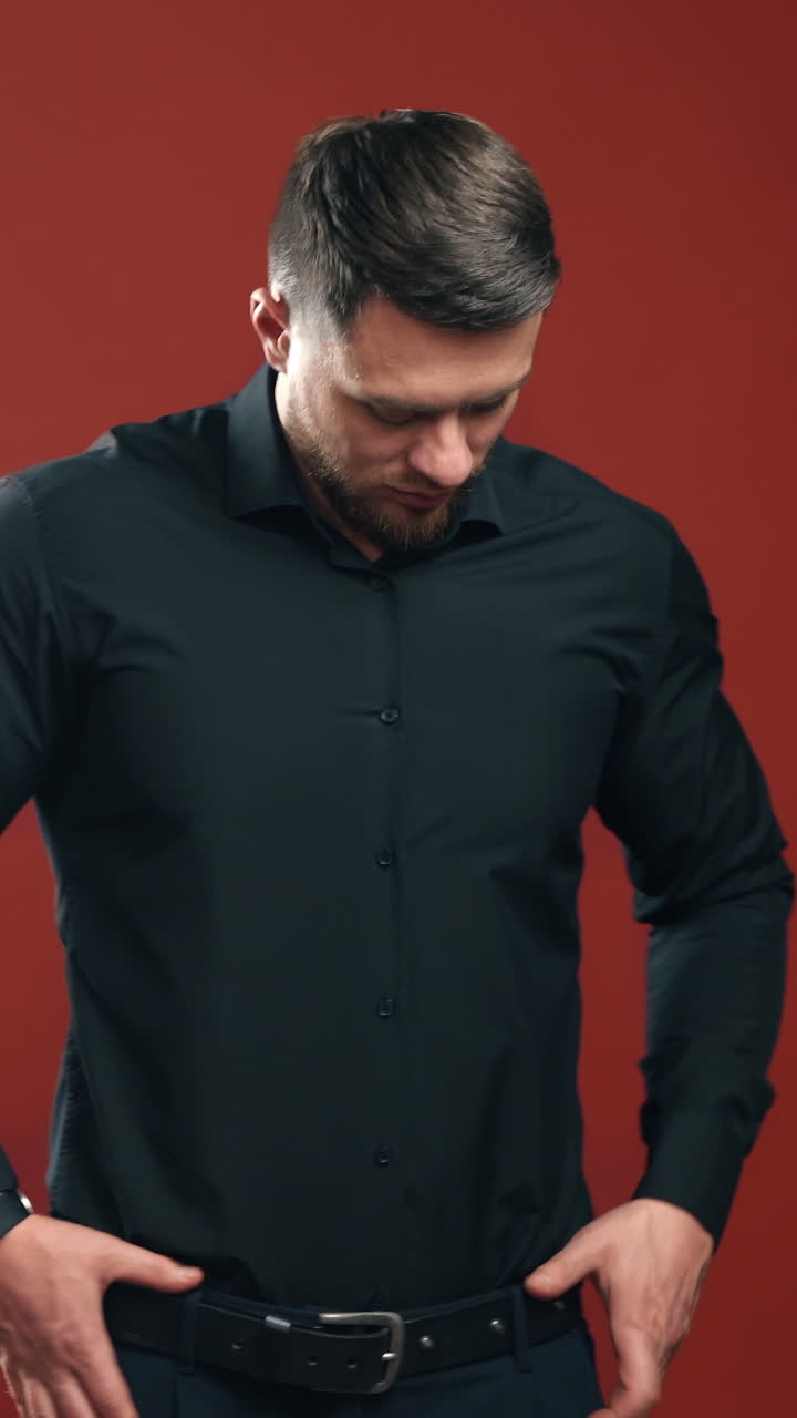 Handsome brunette man. Businessman with attractive appearance in black shirt on bright background. Business concept. Vertical video