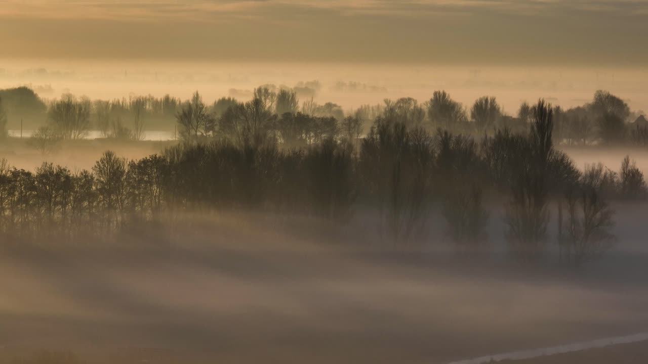 시골 풍경 위의 안개가 가득한 해가 뜨는 모습