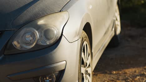 Graue-Autoscheinwerfer-Bei-Sonnenuntergang,-Goldene-Stunde,-Beleuchtung,-Dolly,-Staubige-Motorhaube