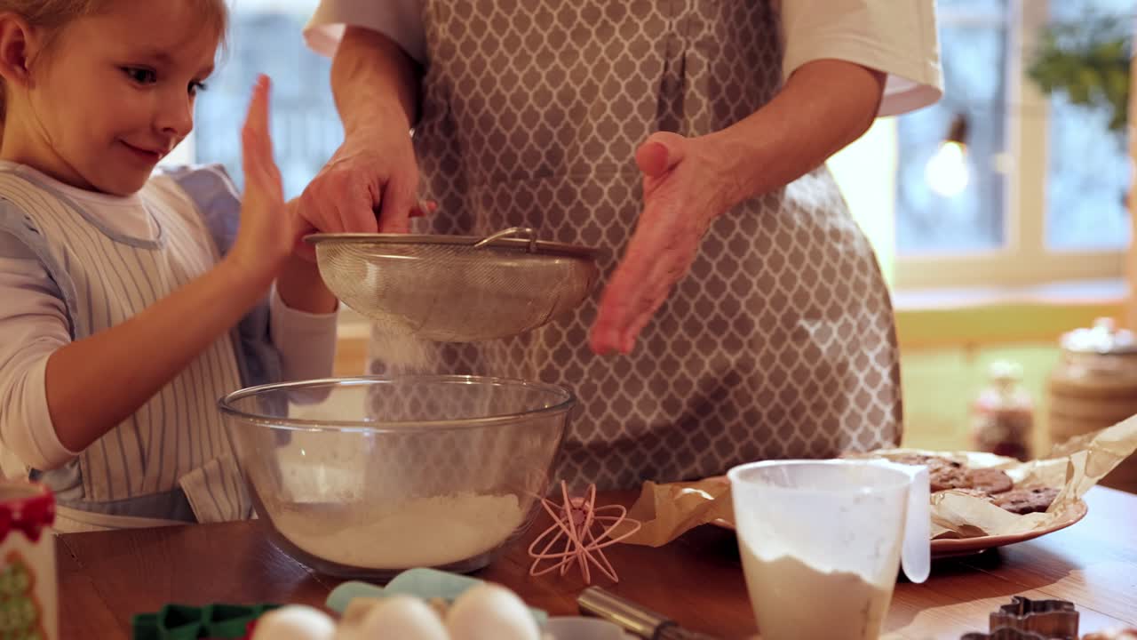 A little girl and her mother bake together