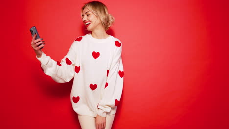 woman taking selfie in a heart sweater