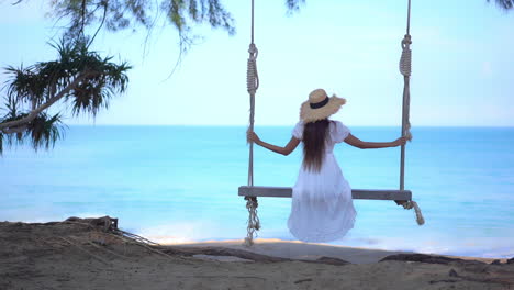 Espalda-De-Mujer-Con-Vestido-Blanco-De-Verano-Cantando-Bajo-Un-árbol-Con-Impresionantes-Vistas-Al-Mar-Tropical