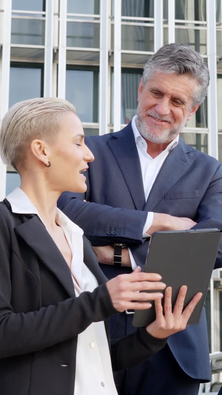 Zakelijke professionals bespreken iets op een tablet buiten