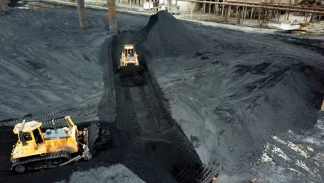 crawler bulldozer works on coal mines. extractive industry, anthracite. aerial view.