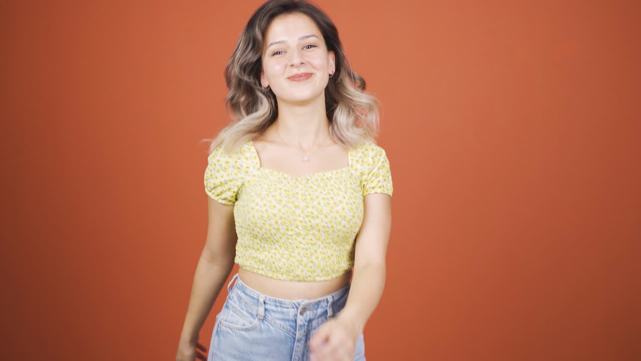 행복한 젊은 여자가 춤을 추고 있습니다.