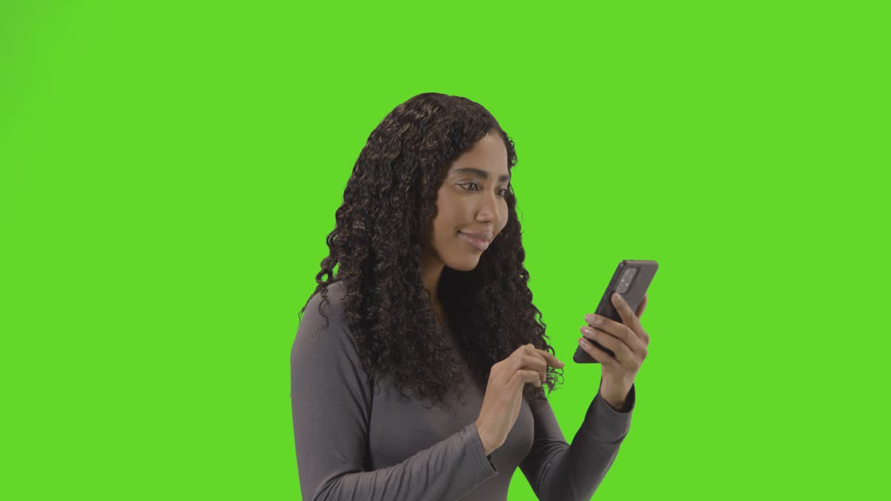 Woman Looking At Mobile Phone And Celebrating Good News Against Green Screen 3