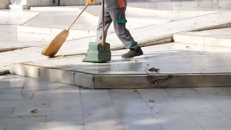 a street sweeper cleans up leaves on a city sidewalk