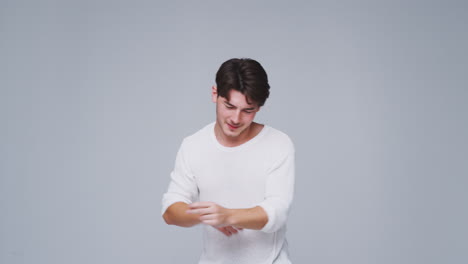 Wide-Angle-Studio-Shot-Of-Young-Man-Against-White-Background-Dancing-In-Slow-Motion