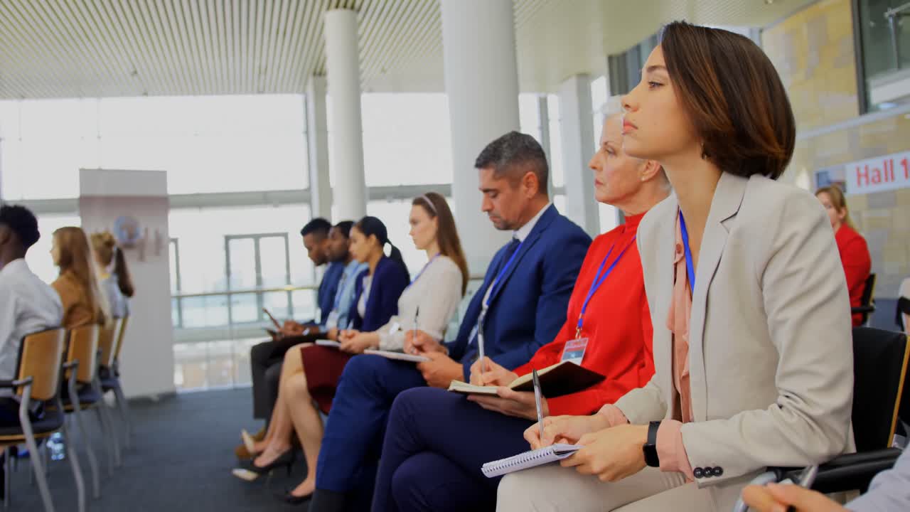 gente de negocios escribiendo en el bloc de notas en el seminario de negocios 4k