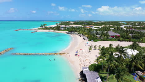 A-forward-downward-medium-shot-capturing-a-serene-coastal-scene-of-white-powdered-sand-beach-adorned-with-beach-huts-and-lounge-chairs,-inviting-relaxation