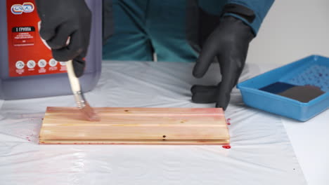 applying wood stain with a brush