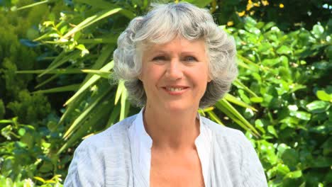 Mature-woman-thinking-and-then-smiling-in-the-garden