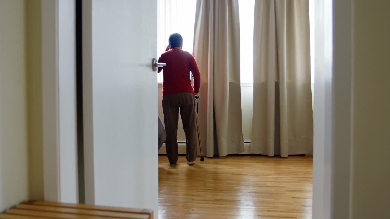 mujer mayor hablando por teléfono móvil en la sala de estar