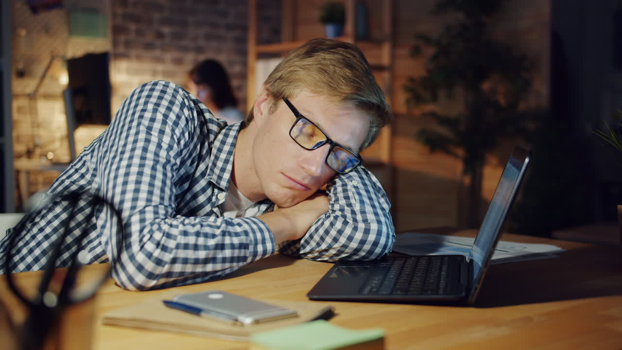 Tired employee sleeping at his desk