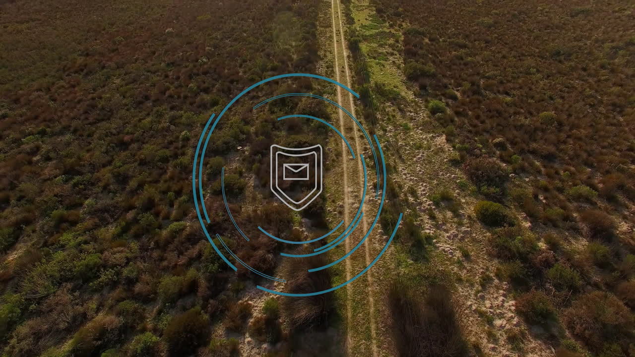 Email security icon animation over aerial view of rural landscape