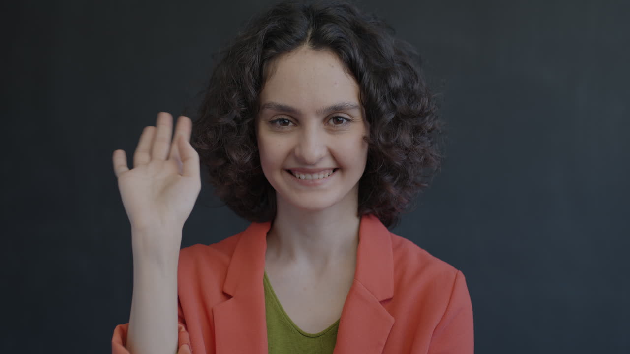 una mujer saludando.