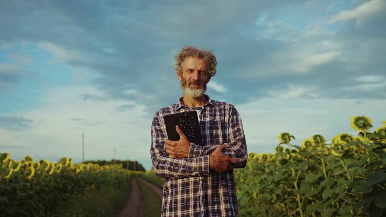 Farmer with Laptop in Sunflower Field