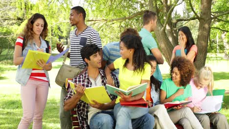 happy students reading and chatting together outside on campus
