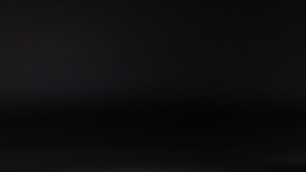Tennis ball bouncing against a dark background