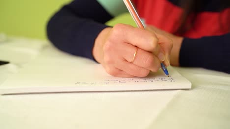 closeup of female hand writing down notes