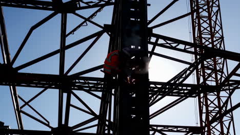 construction worker welding metal beams on a skyscraper
